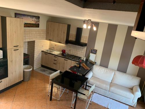 a living room with a couch and a table and a kitchen at Maison Diletta in Castelletto sopra Ticino