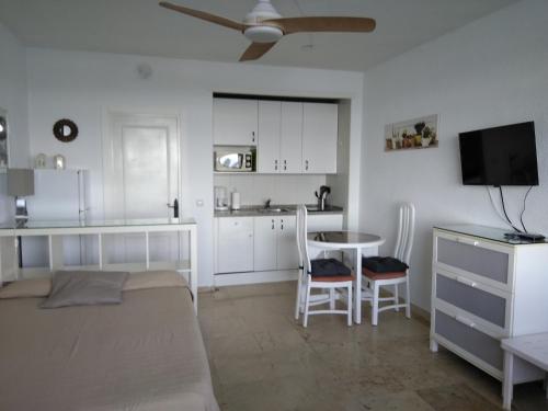 una camera con letto e tavolo e una cucina di Torremolinos 1ª linea playa a Torremolinos