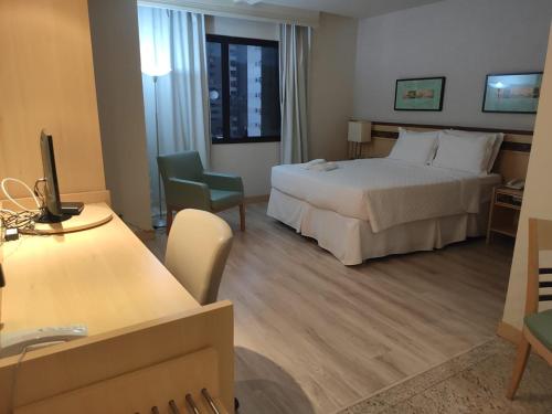a hotel room with a large bed and a desk at Apart Hotel - Esplanada dos Ministérios - Centro de Brasília in Brasilia