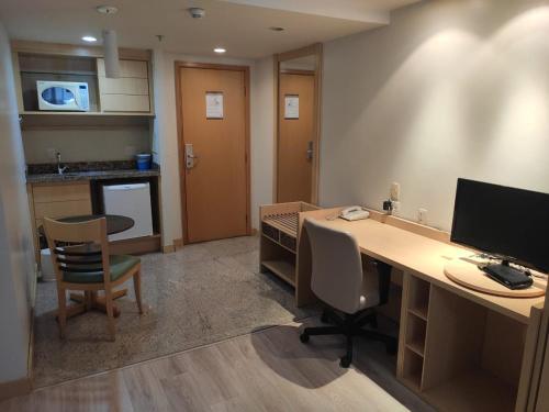 an office with a desk with a computer and chairs at Apart Hotel - Esplanada dos Ministérios - Centro de Brasília in Brasilia