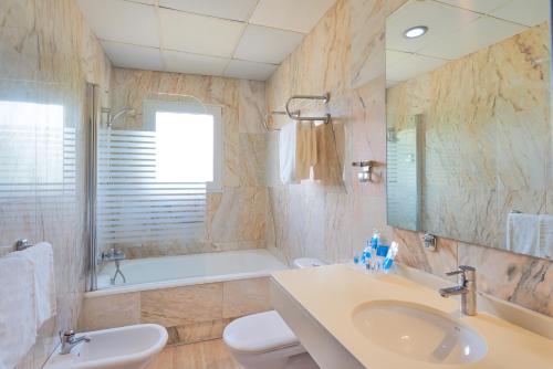 a bathroom with a sink and a toilet and a tub at Crisol Guadalupe in Granada