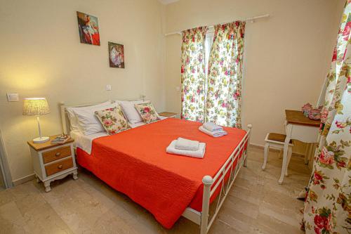 a small bedroom with a bed with a red blanket at Navigator Villas - Houses in Acharavi