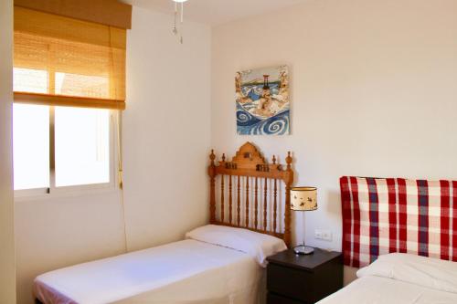 - une petite chambre avec 2 lits et une fenêtre dans l'établissement Espectacular Ático con Parking y Terraza con BBQ, à Salobreña