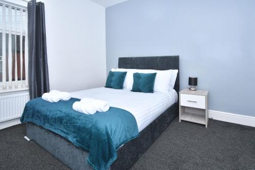 
a bed in a room with a white bedspread at Pegasus House, 3BR Safari Themed Home Open for Contractors in Stoke on Trent
