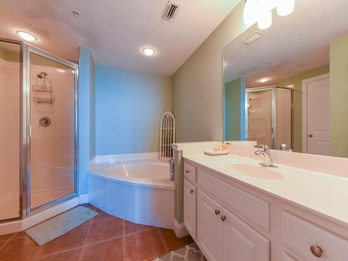 a bathroom with a tub and a sink and a shower at Palazzo II in Panama City Beach