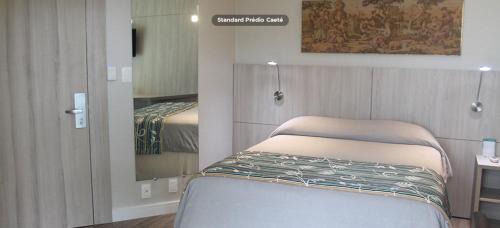 a bedroom with a bed and a dresser at Tauá Hotel & Convention Caeté in Caeté
