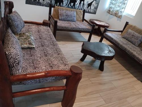 a room with chairs and a couch and a table at MASKANI Villa in Galu