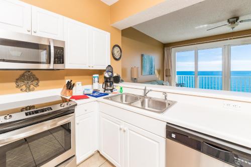 a kitchen with white cabinets and a sink and a window at Windemere Condominiums in Perdido Key