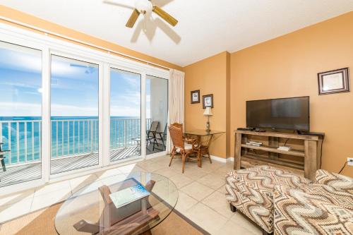 a living room with a flat screen tv and a large window at Windemere Condominiums in Perdido Key