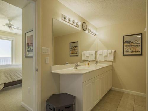a bathroom with a sink and a mirror and a bed at Windemere Condominiums in Perdido Key