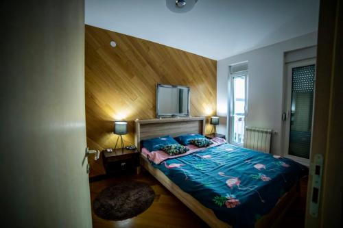 a bedroom with a bed with a flat screen tv on it at Luxury apartmani kg in Kragujevac