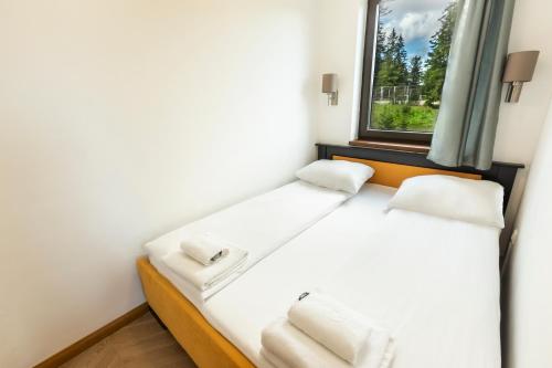 a bed in a room with a window at Jahorinski IZLOG in Jahorina