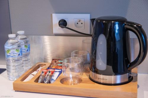 a black coffee pot on a wooden tray with glasses at Modern Living in Huningue