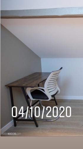 a desk with a white chair sitting under a table at Modern Living in Huningue