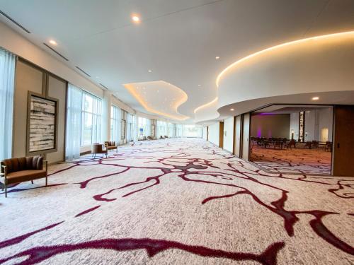 a large room with a carpet with trees on the floor at Omni Viking Lakes in Eagan
