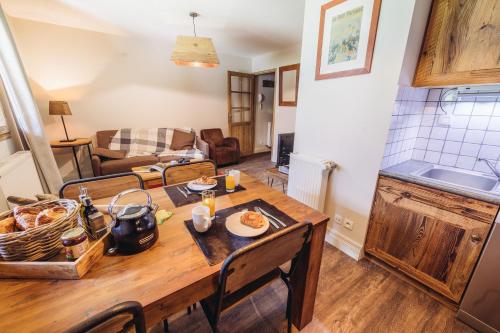 Il comprend une cuisine et un salon avec une table en bois. dans l'établissement Chalet La Perle de L'Oisans - Appartements d'Exception, à Vaujany