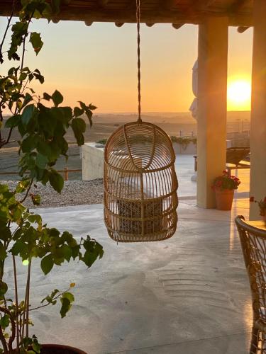 a bird cage hanging from a porch at Monte da Aparica in Galeguinha Grande