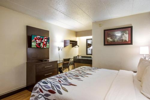 a hotel room with a bed and a desk at Red Roof Inn Saginaw – Frankenmuth in Saginaw