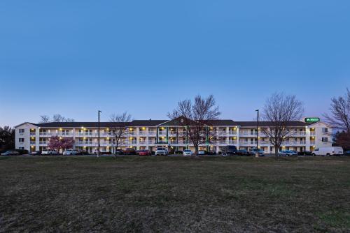 a large building with a parking lot in front of it at HomeTowne Studios by Red Roof Philadelphia - Maple Shade, NJ in Maple Shade