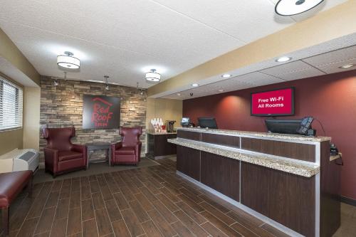 a waiting room with a bar with chairs and a sign at Red Roof Inn Toledo - Maumee in Maumee