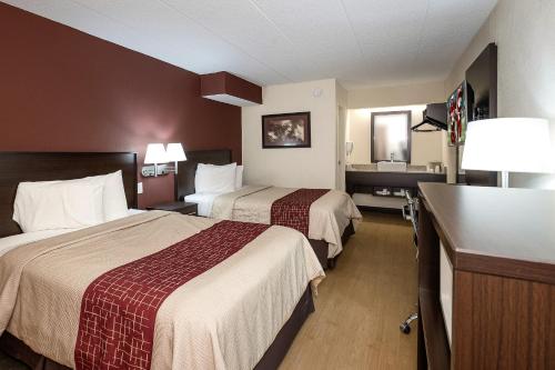 a hotel room with two beds and a bathroom at Red Roof Inn Toledo - Maumee in Maumee