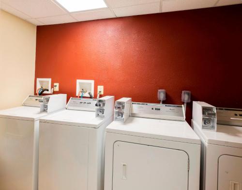 Tres lavadoras están alineadas contra una pared. en Red Roof Inn Edison, en Edison