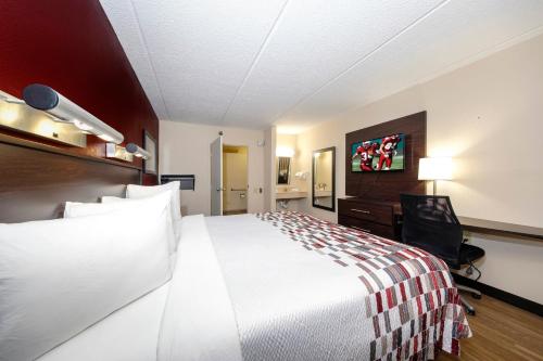 a hotel room with a large bed and a desk at Red Roof Inn Tampa - Brandon in Tampa