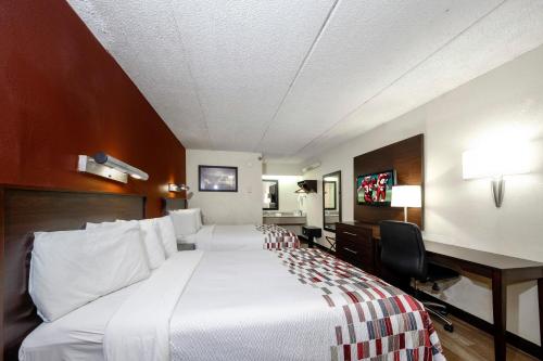 a hotel room with a large bed and a desk at Red Roof Inn Tampa - Brandon in Tampa