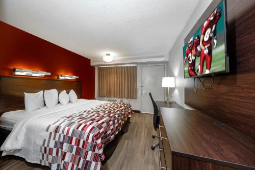a hotel room with a bed and a flat screen tv at Red Roof Inn Tampa - Brandon in Tampa