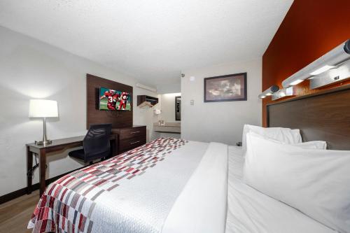 a hotel room with a bed and a desk at Red Roof Inn Tampa - Brandon in Tampa