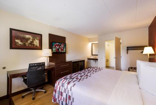 a hotel room with a bed and a desk and a chair at Red Roof Inn Kalamazoo East – Expo Center in Kalamazoo