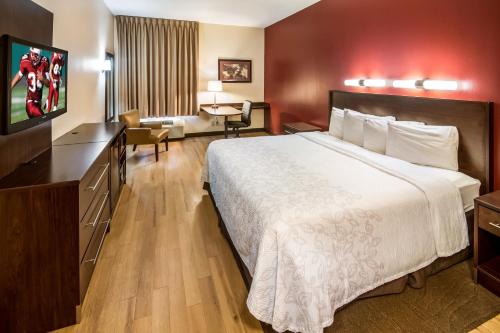 a hotel room with a bed and a television at Red Roof PLUS Long Island - Garden City in Westbury