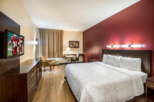 a hotel room with a bed and a desk at Red Roof PLUS Long Island - Garden City in Westbury