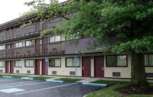 a building with red doors and a parking lot at Red Roof Inn Philadelphia - Oxford Valley in Langhorne