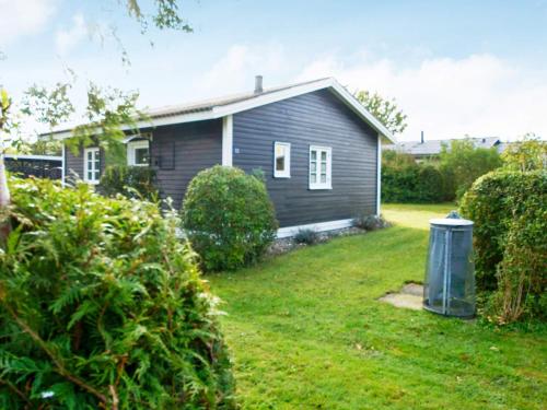 a small house in a yard with a trash can at 4 person holiday home in Hemmet in Hemmet