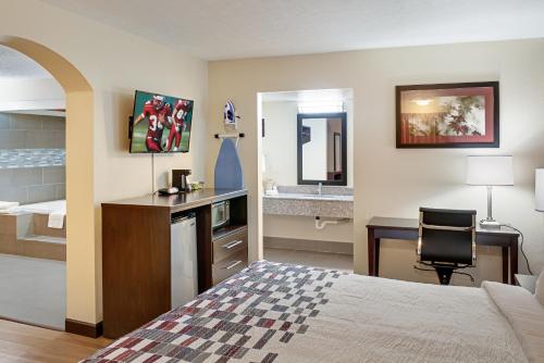 インディアナポリスにあるRed Roof Inn Indianapolis Eastのベッドと机と洗面台があるホテルの部屋