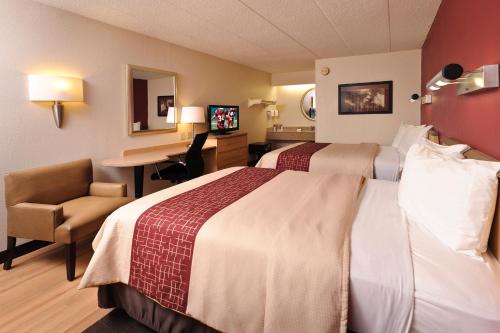 a hotel room with a large bed and a desk at Red Roof Inn Tucson South - Airport in Tucson