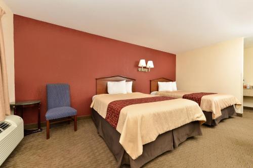 a hotel room with two beds and a blue chair at Red Roof Inn Dalton in Dalton