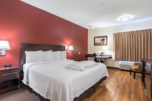 a bedroom with a large bed and a red wall at Red Roof Inn PLUS+ Tempe - Phoenix Airport in Tempe