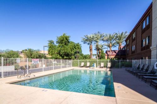 a swimming pool with chairs and a fence at Red Roof Inn PLUS+ Tempe - Phoenix Airport in Tempe