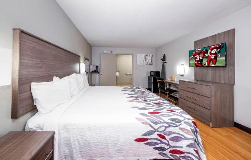 um quarto de hotel com uma cama grande e uma secretária em Red Roof Inn Bay Minette em Bay Minette