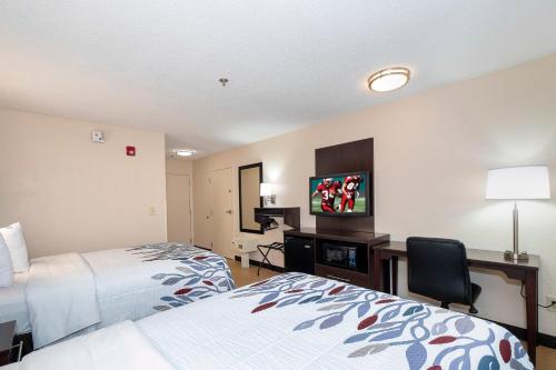 a hotel room with two beds and a flat screen tv at Red Roof Inn Gaffney in Gaffney