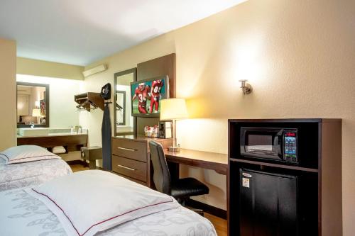 Habitación de hotel con cama y escritorio con TV. en Red Roof Inn PLUS+ Ann Arbor - U of Michigan North, en Ann Arbor