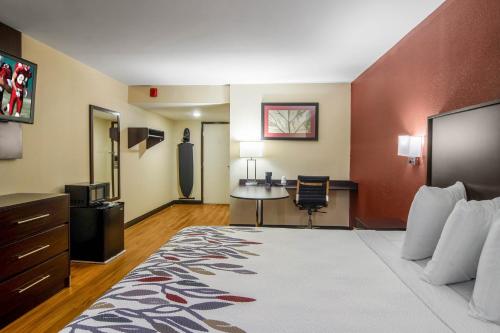 a large hotel room with a bed and a desk at Red Roof Inn Perrysburg in Perrysburg