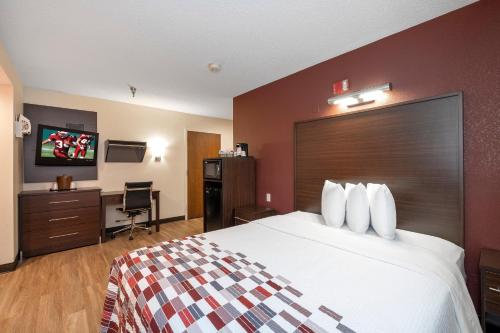 a hotel room with a bed and a tv at Red Roof Inn Springfield, MO in Springfield