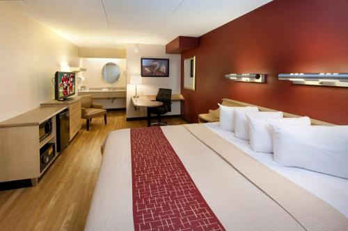 a hotel room with a large bed and a desk at Red Roof Inn Harrisburg - Hershey in Harrisburg