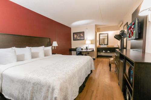 a hotel room with a large bed and a television at Red Roof Inn PLUS+ Columbus - Dublin in Dublin