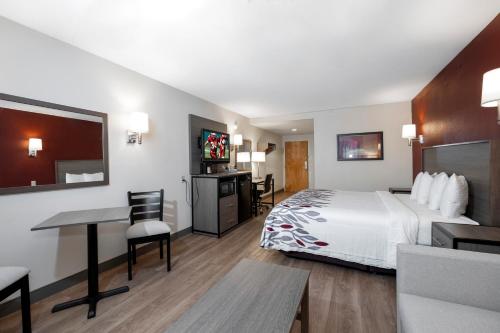 a hotel room with a bed and a desk at Red Roof Inn Clifton Park in Clifton Park