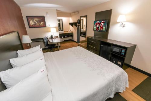 a hotel room with a white bed and a desk at Red Roof Inn PLUS+ Washington DC - Manassas in Manassas