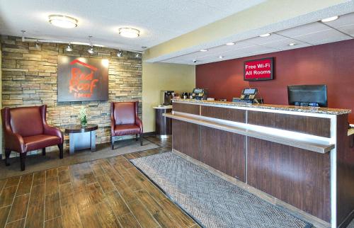 a lobby with a bar with chairs and a waiting room at Red Roof Inn Louisville East - Hurstbourne in Louisville